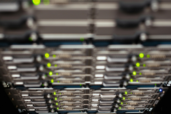 Close-up of server racks in a data center with green status LEDs glowing on the front panels