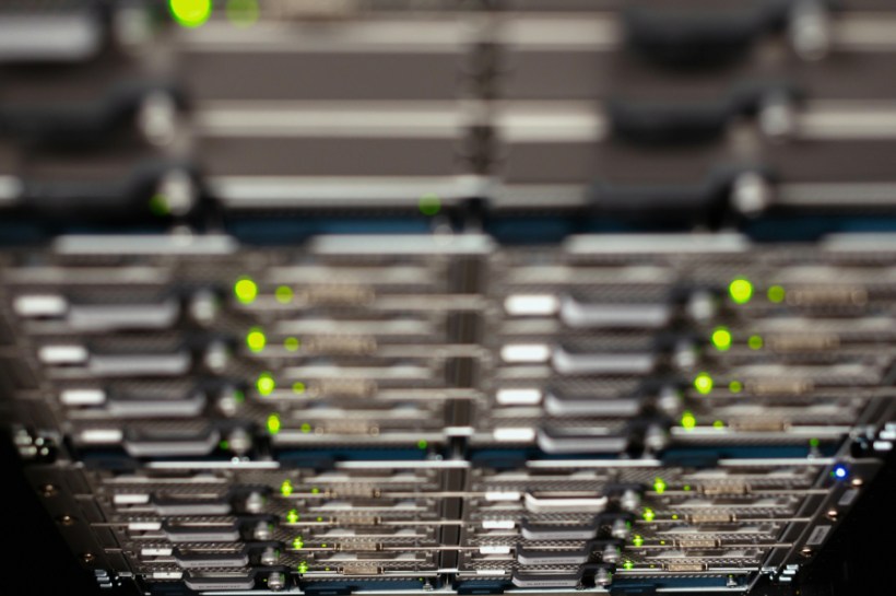 Close-up of server racks in a data center with green status LEDs glowing on the front panels