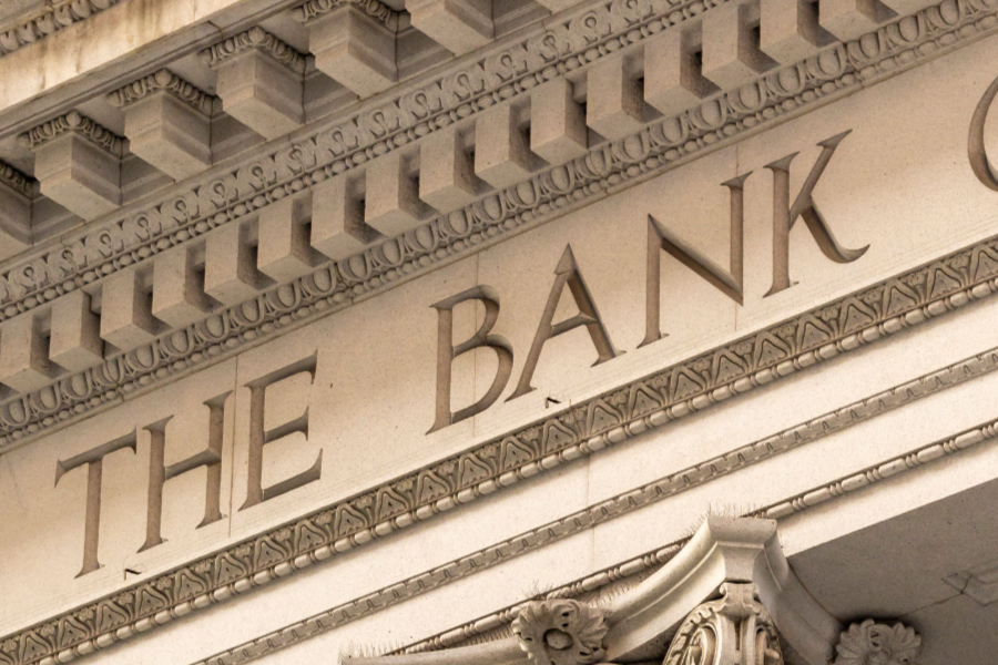Close-up of a classical bank facade with ornate molding and the carved words THE BANK.