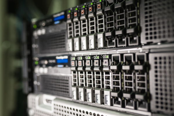 Rows of server blades in a data center rack with green indicator lights and drive bays visible