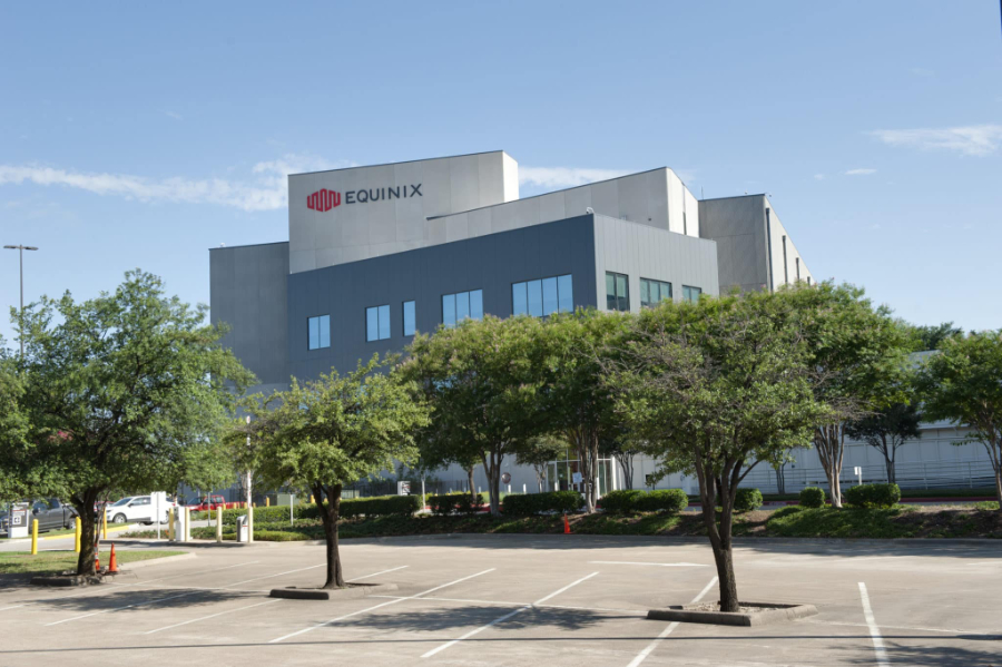 Equinix corporate building with blue facade and surrounding trees in a parking lot.